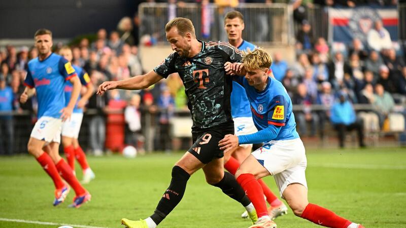 Bayern demontiert Kiel mit 6:1 und übernimmt Tabellenführung Bayerns Harry Kane (l-r) behauptet den Ball gegen Kiels Finn Porath.