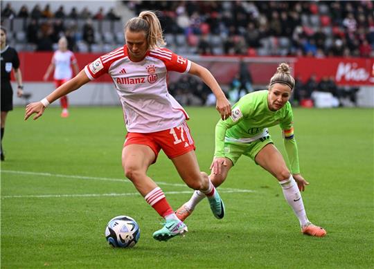Bayerns Klara Bühl (l) kämpft mit Wolfsburgs Svenja Huth um den Ball.