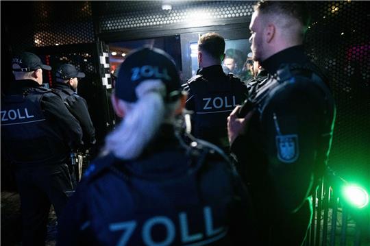 Beamte des Zoll stehen während einen Razzia vor einem Club.
