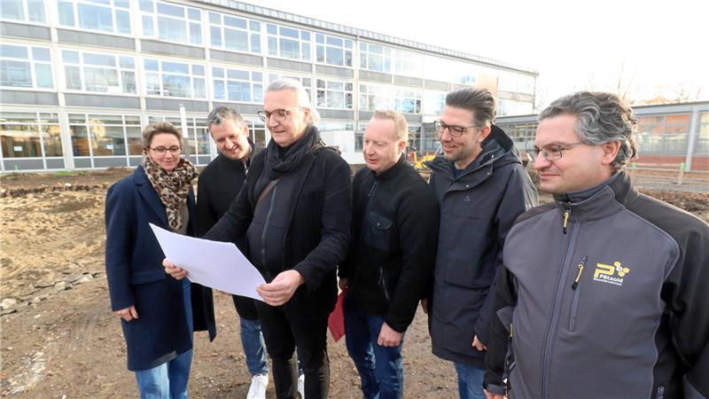 Personen betrachten vor der Grundschule Hornburg Pläne