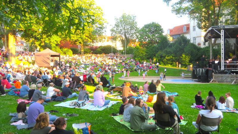 Bei bestem Wetter lauschen die Gäste auf ihren Picknick-Decken dem Orchester.