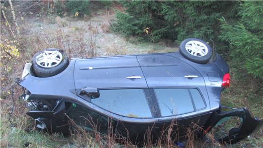 Bei dem Unfall überschlägt sich der Wagen und bleibt auf der Seite im Staßengraben liegen.