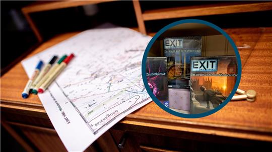 Auf einem Tisch liegen Zettel und Stifte. In einem kleinen Bild sind drei verschiedene „Exit“-Spiele zu sehen. 