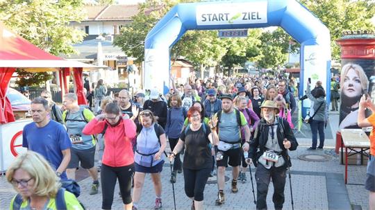 Menschen wandern durch eine Fußgängerzone. 