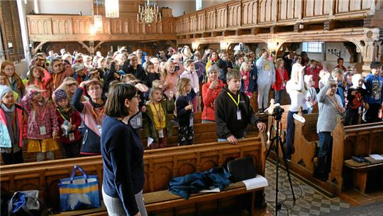 Bei den Liedern, die die Teilnehmer der Kinderbibelwoche singen, stehen die Kinder auf den Bänken in der Kirche.