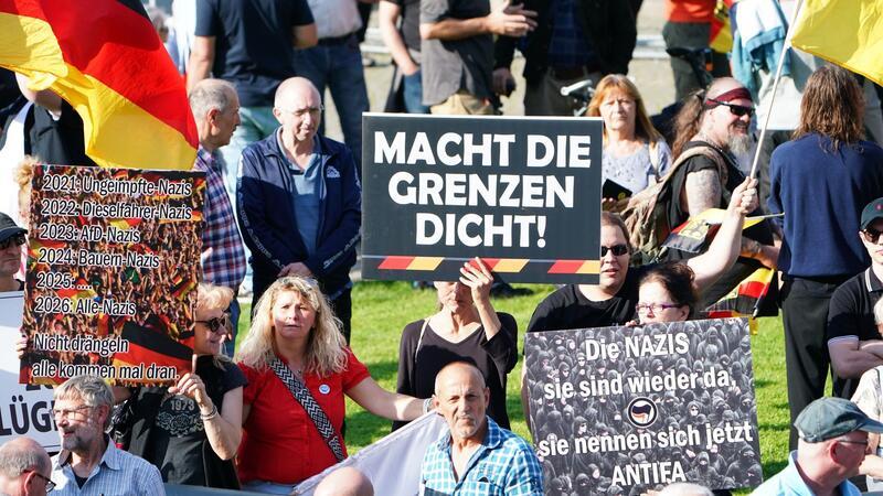 Mannheim: Tausende Menschen gedenken des toten Polizisten Bei der Kundgebung in Mannheim waren neben Deutschland-Fahnen auch Banner mit Aufschriften wie „Remigration jetzt“ und „Macht die Grenzen dicht“ zu sehen.