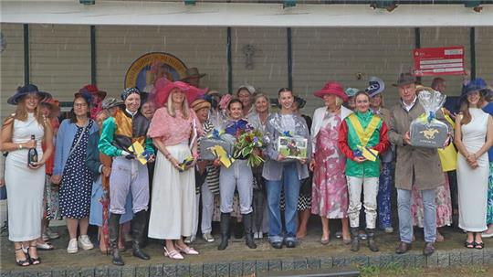 Bei der Renwoche 2025 findet die Siegerehrung der „Damenwahl“ bei strömendem Regen statt. Doch davon lassen sich die Teilnehmerinnen nicht verdrießen, 2026 soll es wieder ein Amazonenrennen geben.