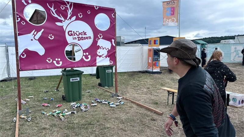 Für den guten Zweck: Die Pfandsammler des Rockharz-Festivals Bei der Torwand von „Glück in Dosen“ können Festivalbesucher leere Dosen auf die Löcher werfen und etwas gewinnen.