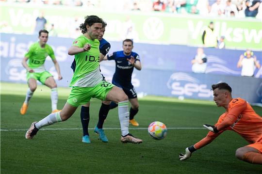 Bei einem Spiel im Mai diesen Jahres spielt Wolfsburgs Jonas Wind (l) gegen Hertha BSCs Torwart Tjark Ernst.