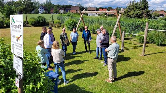 Eine Gruppe von Menschen steht auf einem Spielplatz.