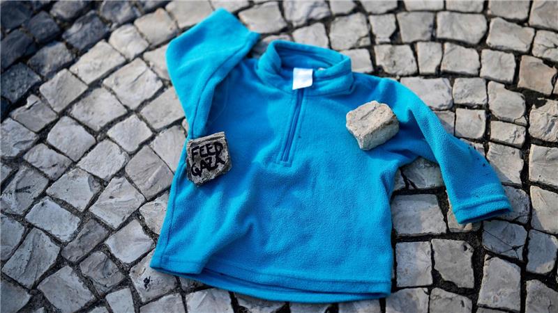 Bei einer Demonstration gegen den Krieg in Gaza liegt Kinderkleidung neben Listen von im Gazastreifen getöteten palästinensischen Kindern auf dem Boden in der Innenstadt von Lissabon.