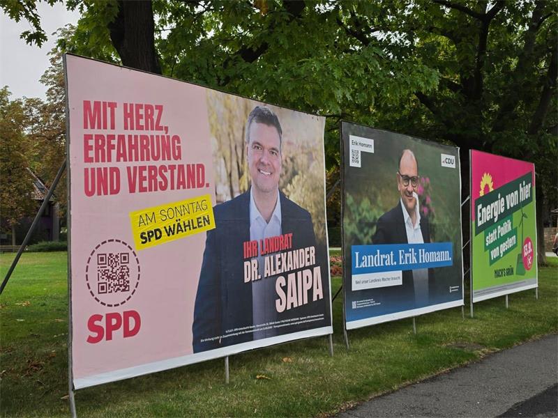 Blick auf drei Wahlplakate.