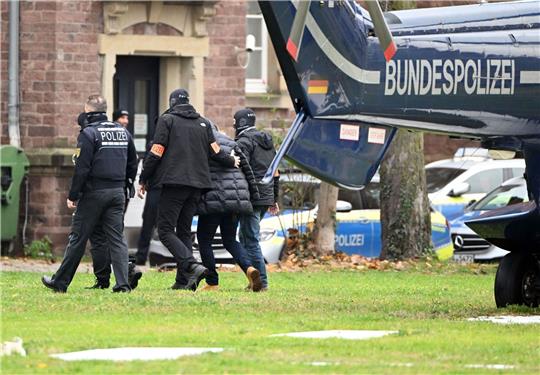 Beim Bundesgerichtshof in Karlsruhe wird eine Person von Polizisten aus einem Hubschrauber gebracht.