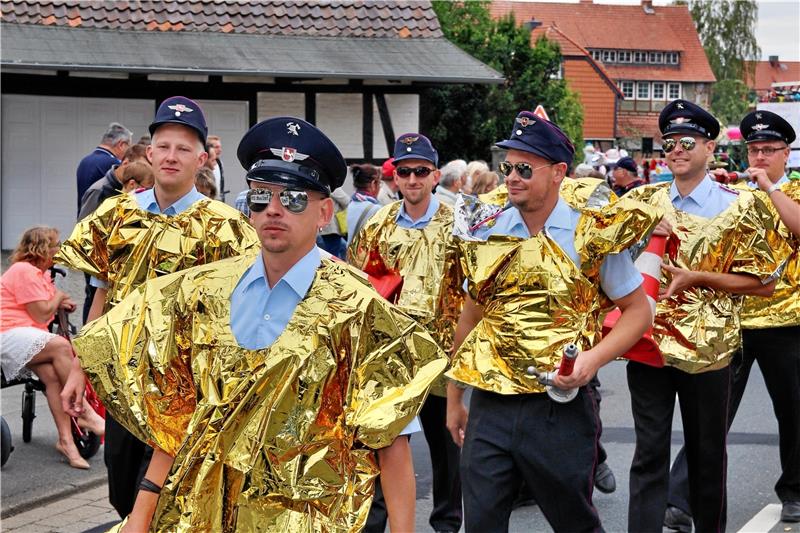 Beim Festumzug wird schon mal die Uniformjacke weg gelassen und – dem spaßigen Charakter der Veranstaltung angemessen – zur goldfarbenen Rettungsdecke als Poncho gegriffen. Ausgerüstet mit allerhand Feuerwehr-Utensilien bereitet auch den Brandbekämpfern der alljährliche Dorffestumzug viel Freude. Fotos: Leifeld