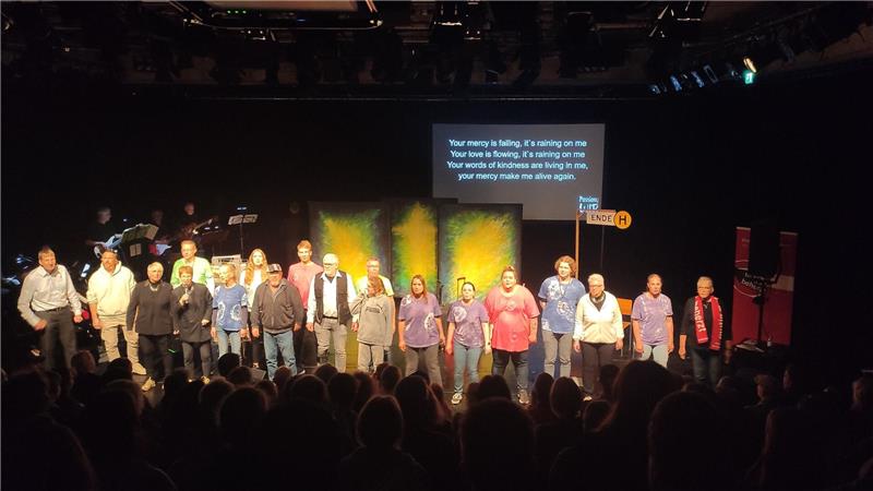 Viele Personen auf einer Bühne. 