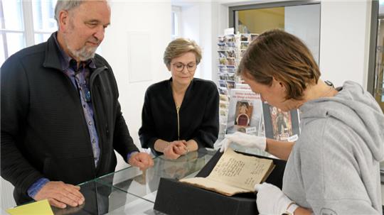 Beim Ortstermin Mitte Mai in der Marktkirchenbibliothek: Restauratorin Katharina Lußky (rechts) schaut sich ein Buch an, das sie restaurieren soll. Helmut Liersch, der Beauftragte für die Marktkirchenbibliothek, hat eine Liste beschädigter Bücher zusammengestellt, die dringend repariert werden müssen. Die Fördervereins-Vorsitzende Elke Brummer sorgt sich derweil um die Finanzierung.