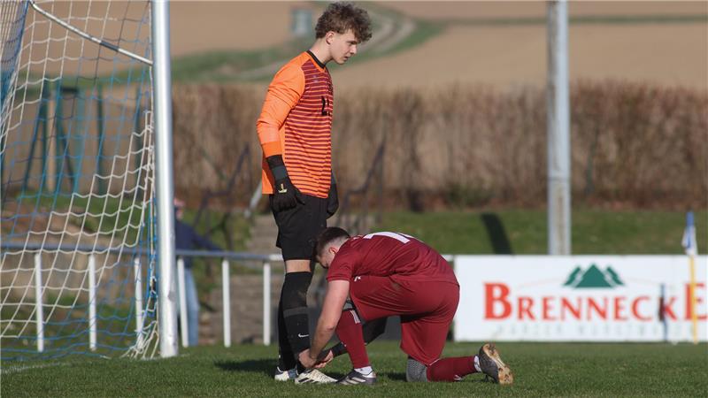 Derbe Pleite für Groß Döhren im Topspiel Fußballtorwart in orange-schwarzer Kleidung steht im Tor während ein Spieler in roter Kleidung seine Schuhe bindet