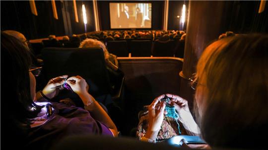 Beim „Strick-Kino“ wie hier in Mannheim stricken die Kinobesucher(innen) und genießen nebenher einen Film.