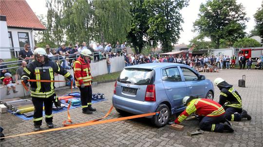Beim Tag der offenen Tür zum 130-jährigen Bestehen zeigt die Ortswehr Hahausen, wie eine eingeklemmte Person aus einem Auto gerettet wird. Dazu stabilisieren die Aktiven unter anderem das Fahrzeug.