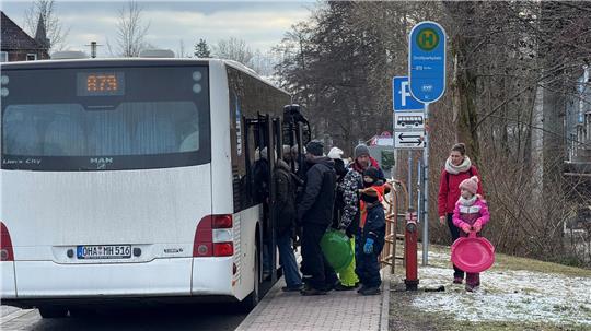 Gäste steigen in den Skibus zum Hexenritt ein, sie haben Schlitter und Rodel dabei.