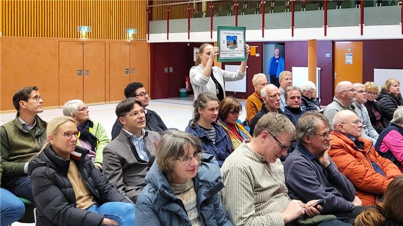 Bente Buchenauer von der Bürgerinitiative für einen lebenswerten Oberharz hält vor einigen Monaten ein Schild gegen den geplanten Windpark in Werk Tanne hoch.