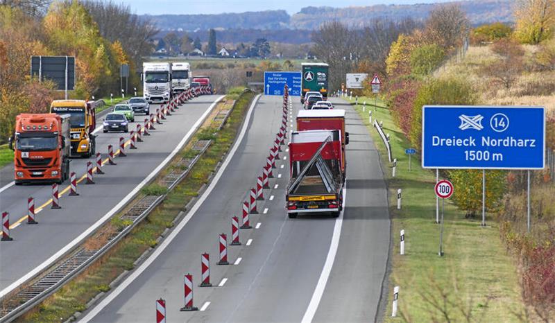 Auf einer Autobahn ist eine Fahrspur mit rot-weißen Baken abgesperrt.