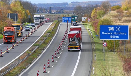 Auf einer Autobahn ist eine Fahrspur mit rot-weißen Baken abgesperrt.
