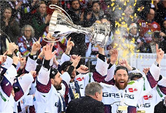 Berlins Spieler jubeln nach dem 2:0-Sieg mit dem Pokal über die zehnte deutsche Eishockey-Meisterschaft.