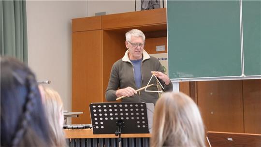 Bernd Nawothnig spielt vor den Zehntklässlern des NIGs ein Solo auf der Triangel.