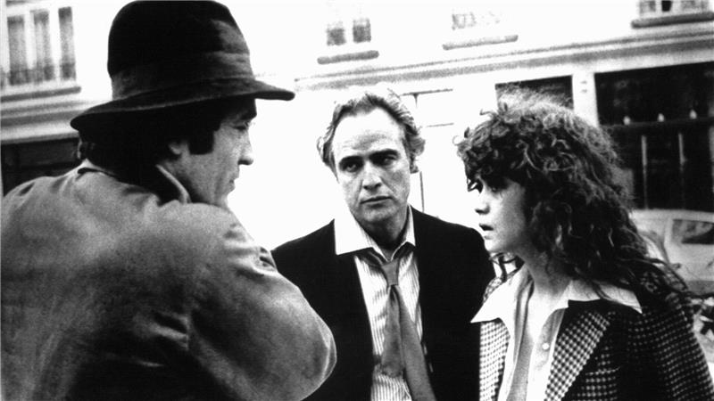 Skandalfilme, die empört haben Bertolucci (l) im Gespräch mit seinen Hauptdarstellern Marlon Brando und Maria Schneider bei den Dreharbeiten zu dem Film „Der letzte Tango in Paris“ 1972.