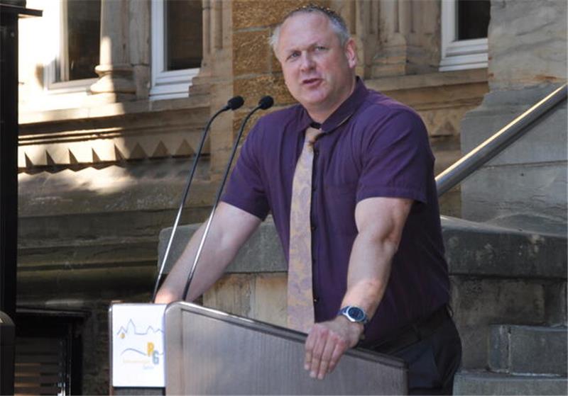 Michael Kwasniok steht auf dem Pausenhof des Ratsgymnasiums an einem Sprechpult. 