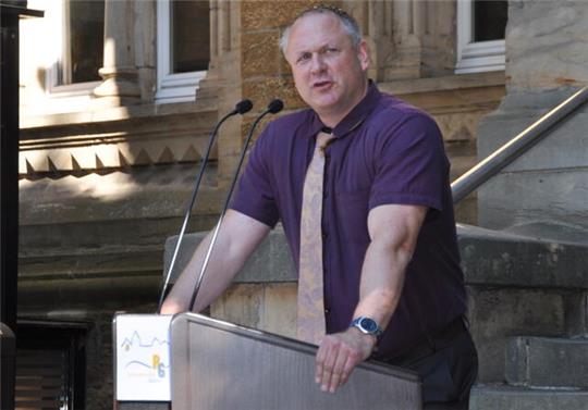 Michael Kwasniok steht auf dem Pausenhof des Ratsgymnasiums an einem Sprechpult. 