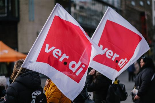 Beschäftigte der Sozial- und Erziehungsberufe demonstrieren mit Verdi-Fahnen in der Innenstadt.