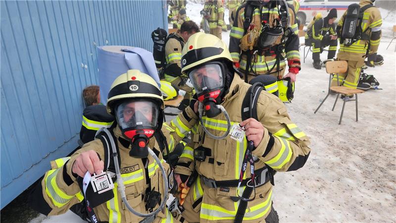 Feuerwehrleute in Ausrüstung posieren für ein Foto.