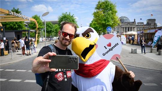 Besucher Bastian aus Bergisch-Gladbach macht mit „Freddi dem Familienadler“ ein Selfie: Andenken an die Feier für das Grundgesetz.