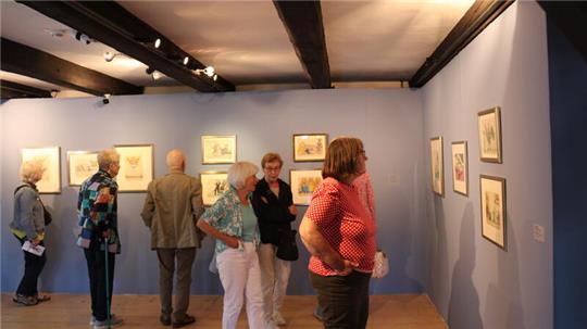 Besucher der Ausstellung "Der dreifache Mondweltmeister" im Goslarer Mönchehaus betrachten die Bilder von Friedrich Schröder-Sonnenstern.