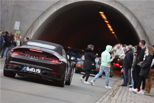 Besucher eines Autotunertreffens stehen am Tunnel der Rappbodetalsperre und beobachten die Fahrzeuge im Tunnel. Fans der Tunerszene haben sich zum „Car-Freitag“ den Tunnel, die sogenannte „Soundröhre“, als beliebten Treffpunkt der Szene ausgesucht. Foto: Matthias Bein/dpa