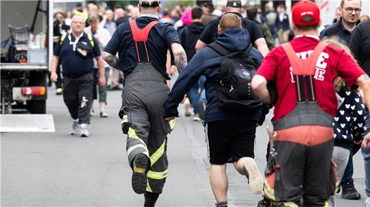 Besucher rennen zu Messebeginn auf der Messe Interschutz, um in Halle 15 einen von 1.000 kostenlosen Rucksäcken am Stand von Haix zu ergattern.