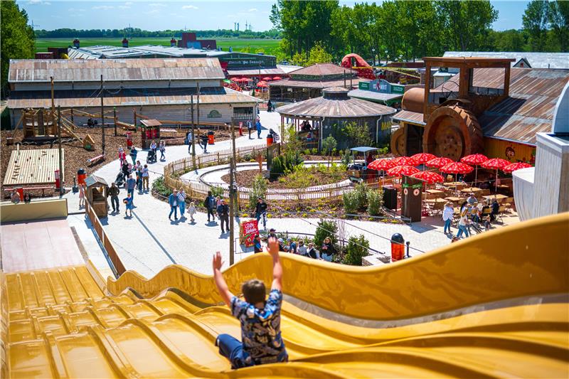 Ein Kind rutscht in einem Freizeitpark eine Rutsche hinab.