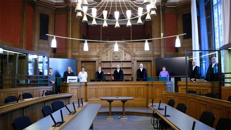 „Nimmt mich mit“: Scheuer nach Mautdebakel vor Gericht Beteiligte des Prozesses gegen Ex-Minister Andreas Scheuer (CSU) warten im Gerichtssaal.