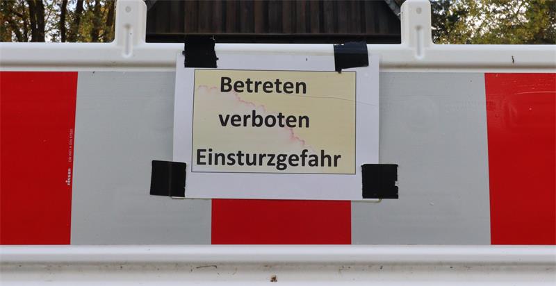 Ein Schild mit der Aufschrift "Betreten verboten - Einsturzgefahr" an einer Baustellenbake.