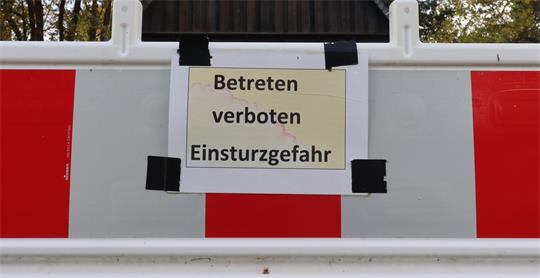 Ein Schild mit der Aufschrift "Betreten verboten - Einsturzgefahr" an einer Baustellenbake.