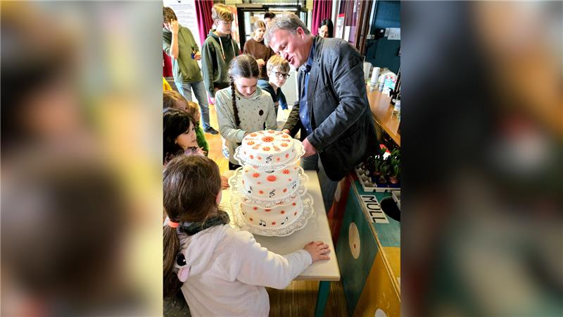 Zum Telemann-Geburtstag gibt es in Clausthal eine Riesen-Torte Bettina hat auch Geburtstag. Sie wird zwölf und darf die Torte anschneiden – Kantor Janssen hilft dabei. Foto: Weiss