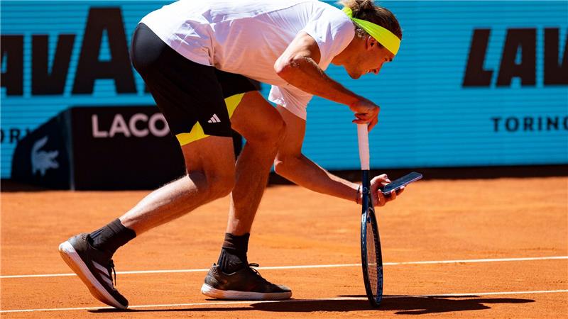 Beweismittelaufnahme: Alexander Zverev fotografiert mit seinem Handy den Abdruck des Balls auf der Linie.