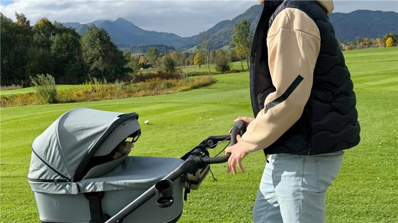 Biathlet Johannes Kühn schiebt seine Tochter im Kinderwagen. 