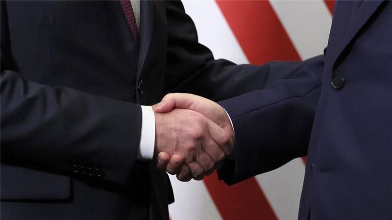 Biden und Xi geben sich die Hand. 