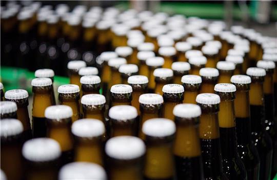 Bierflaschen mit Kronkorken in einer Produktion der Brauerei: «Der Promotionpreis von 9,99 Euro je Kiste verschwindet allmählich.»