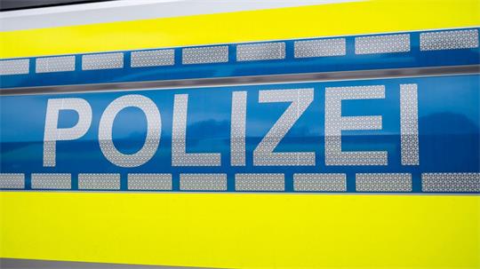 Das Wort „Polizei“ steht auf einem Polizeiauto.