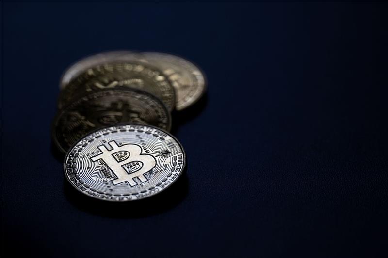 Preis für Bitcoin fällt nach Rekordhoch deutlich Bitcoin-Münzen liegen auf einem Tisch.