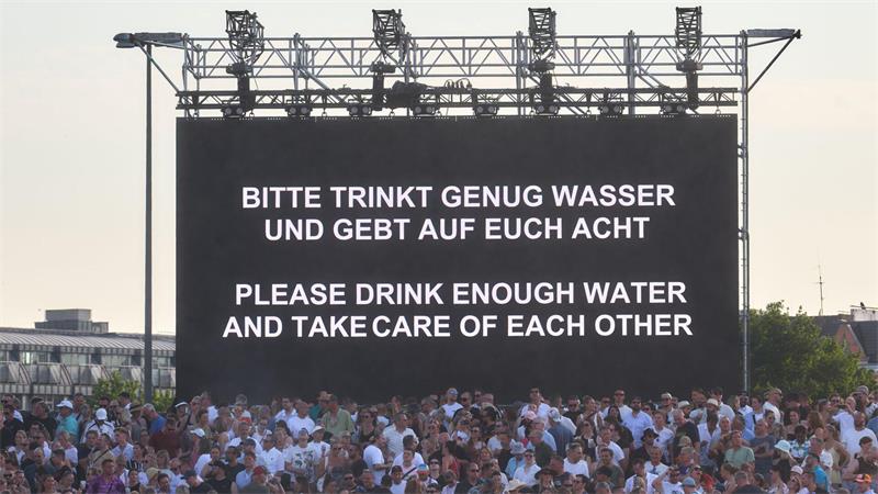 „Bitte trinkt genug Wasser und gebt auf Euch Acht“ steht bei hochsommerlichen Temperaturen auf einer Leinwand bei einem Konzert von Techno-Star Paul Kalkbrenner auf dem Heiligengeistfeld in Hamburg.